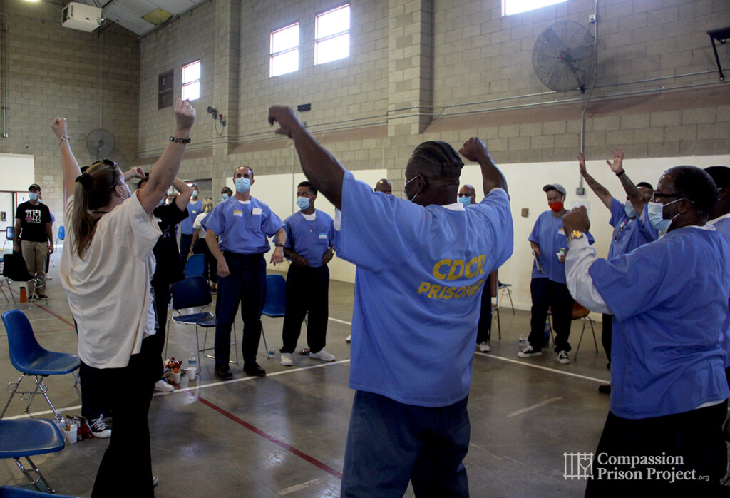 Group of people standing in circle with arms up