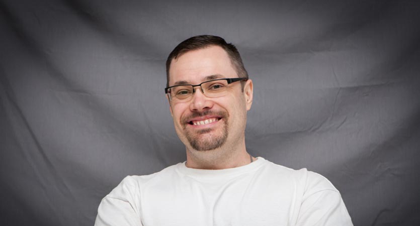 Man standing smiling with arms crossed