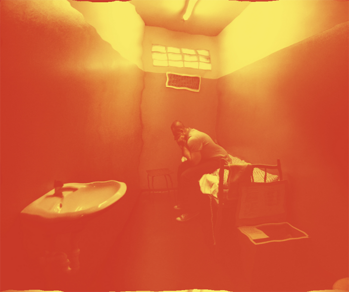 Man sitting in hot prison cell